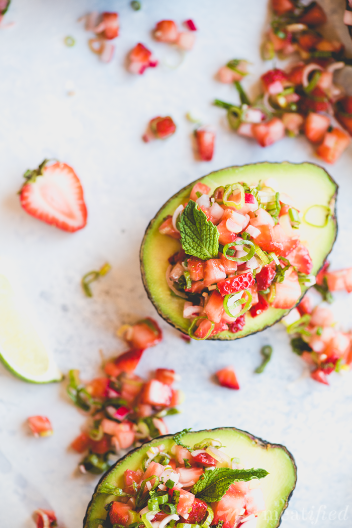 Avocado halves filled with a nightshade free strawberry salsa from http://meatified.com make a quick, easy and pretty appetizer or side for all those summer nights & cookouts.