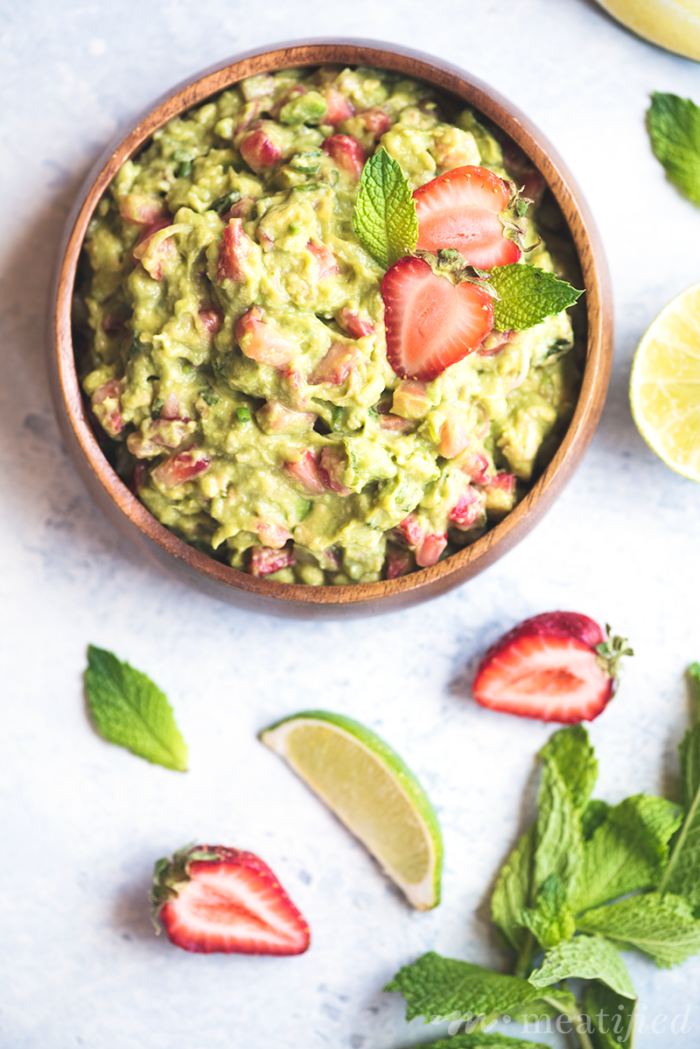 Switch up your guac game with this summery Strawberry Guacamole from http://meatified.com. Flecked with strawberries, green onion & mint for a fun twist on the classic favorite.
