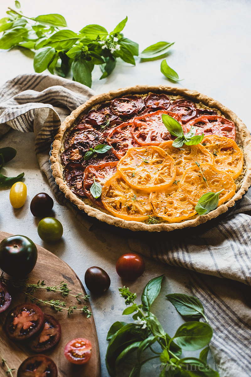 Nothing says summer better than this tomato tart layered with herbed vegan ricotta and heirloom tomatoes, all wrapped in a savory grain free crust.
