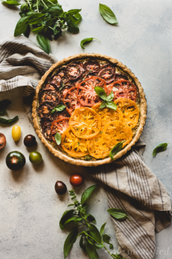 Nothing says summer better than this tomato tart layered with herbed vegan ricotta and heirloom tomatoes, all wrapped in a savory grain free crust.